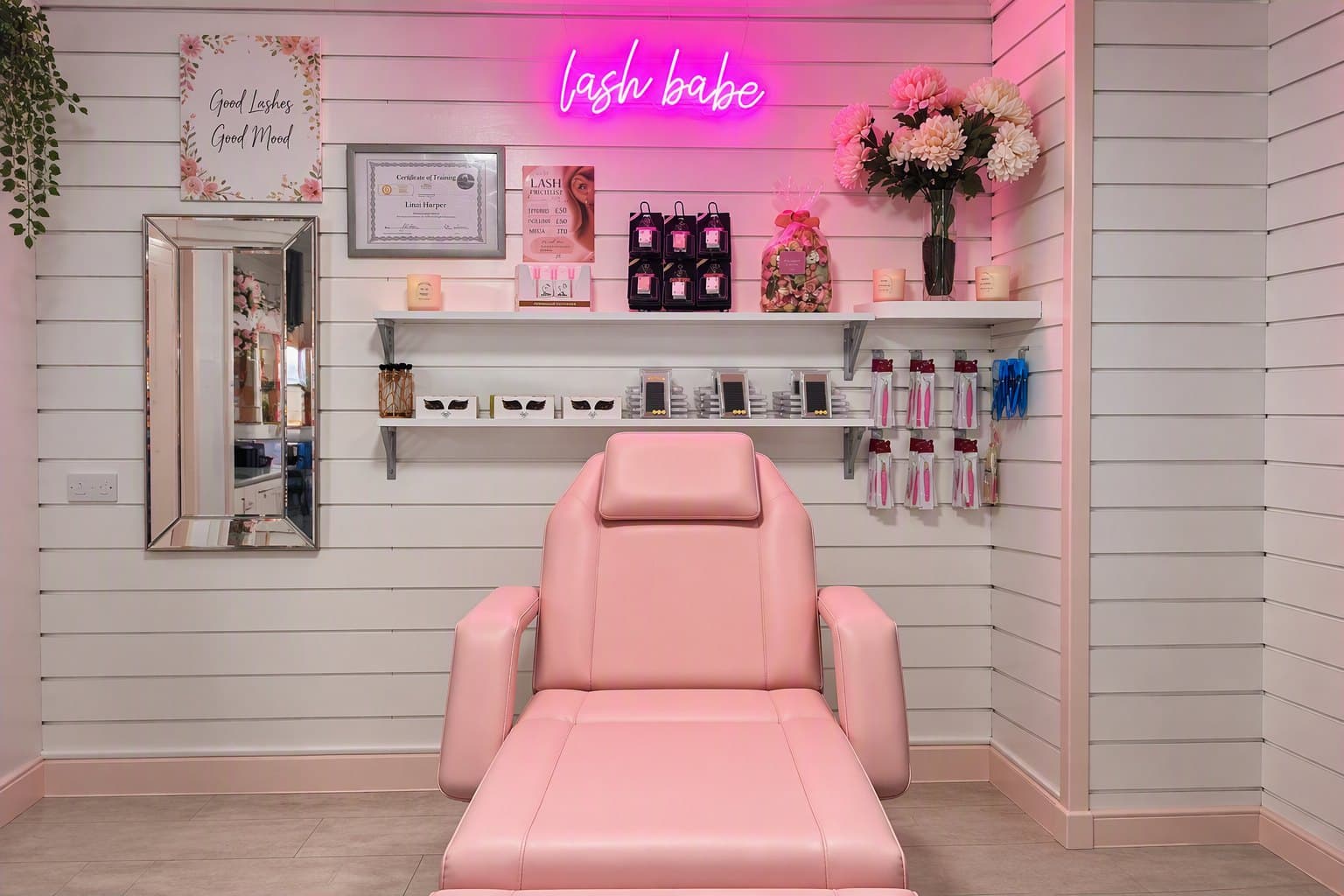 Our real lash and brow studio — the reclining treatment bed beneath the glowing 'lash babe' neon