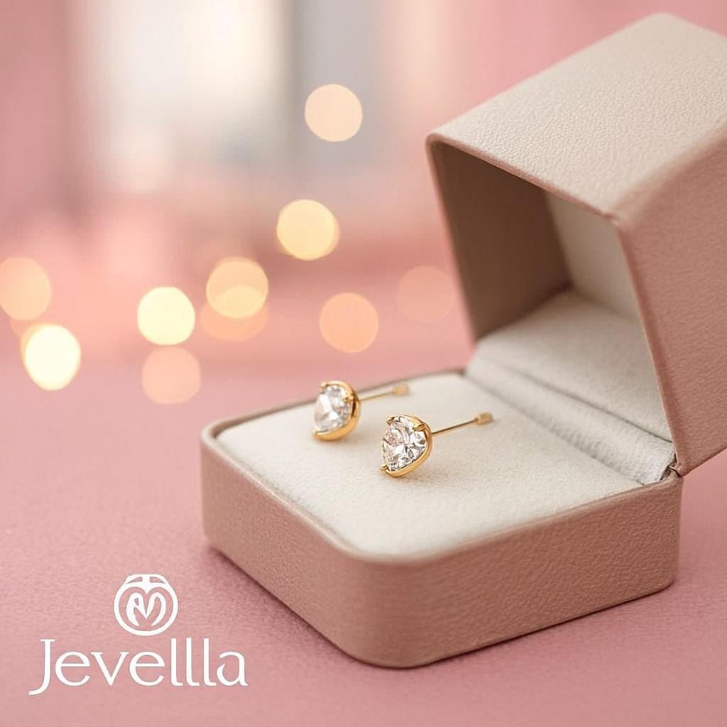 Delicate gold stud earrings presented on white velvet